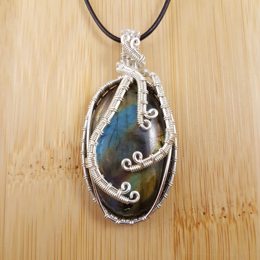 Large bronze and blue diagonal striped oval pendant wrapped in wavy silver wire.