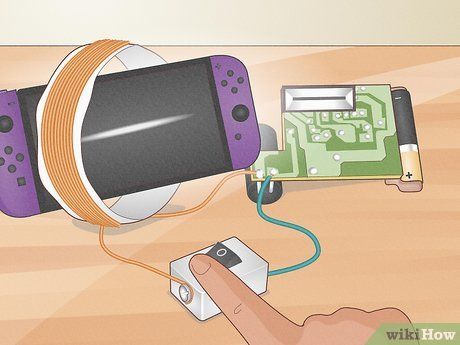 wikihow illustration showing a camera flash circuit hooked up to a coil of wire, around a nintendo switch