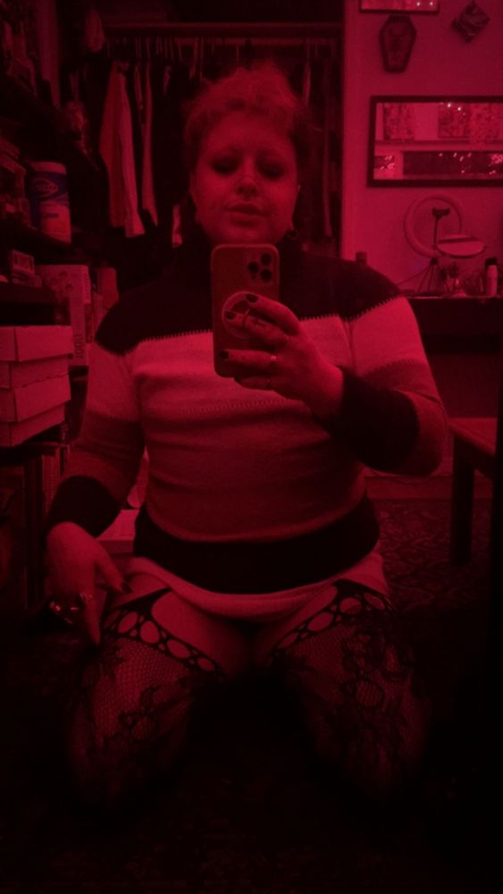 in the full length mirror, kneeling on the ground in my sweater dress and stockings