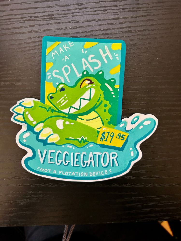 a furry con badge in the style of a toy ad with the name Veggiegator, showing a green pool toy alligator character splashing in water.