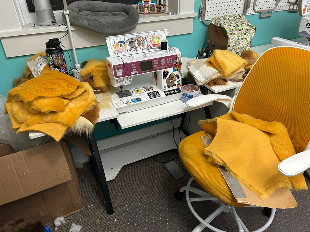a sewing machine table with many pieces of cut out faux fur on it 
