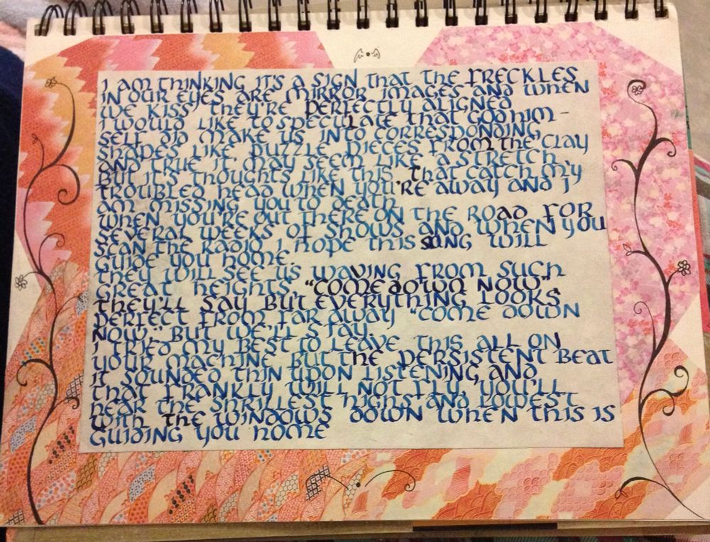 a calligraphy rendition of the lyrics to “such great heights” clumsily penned, against a collage of pink hued origami paper in an old sketchbook