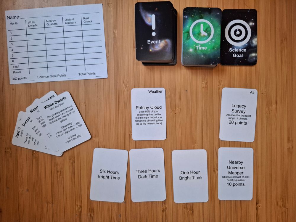 Decks of cards marked Event, Time and Science Goal. Some of the cards lie face up. A scoresheet lies next to the cards.