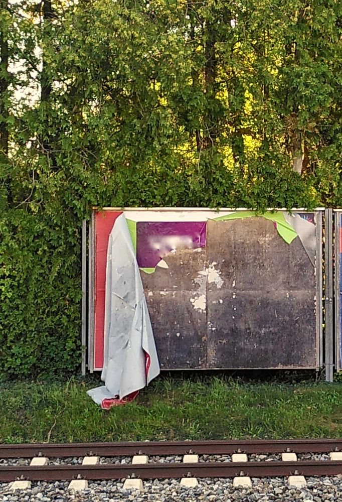 Abgelöste Plakate hängen schlapp nur noch am Rand der Plakatwand.