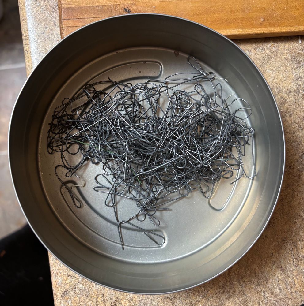 A tangle of ornament hooks in a 100-foot film roll can.