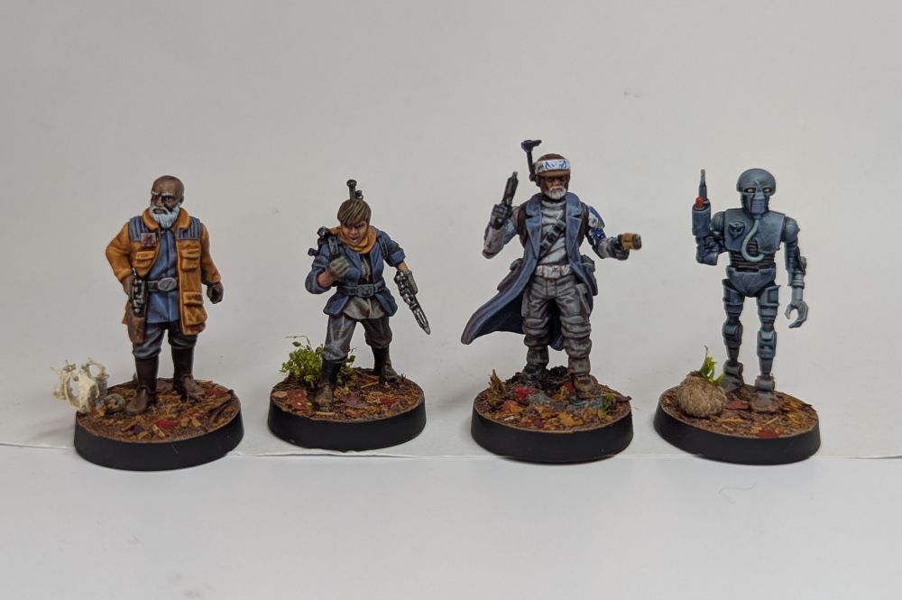 4 painted miniatures. L to R: A man in a jacket with a hand on his holstered blaster, a woman yelling into a radio reciever, a man duel welding pistols and a surgical robot holding up a syringe hand.