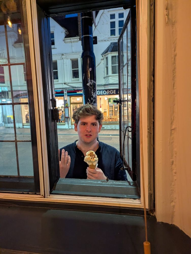 Boy at the window, holding an ice cream.