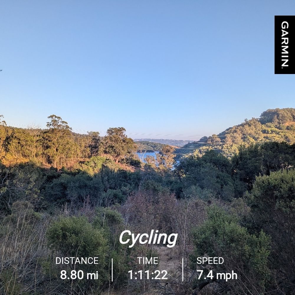 A view of Lake Chabot at sunset from the western rim, overlaid with text reading, "Cycling distance 8.80 mi time 1:11:22.speed 7.4mph"