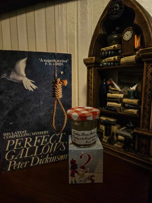 Cover of Perfect Gallows, little cute cube with a 2, and little jam jar, with my wooden toy bookshelf