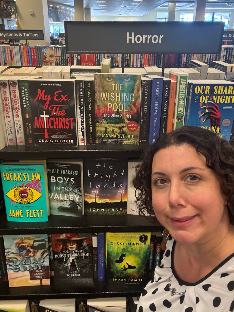 KC in front of bookshelf