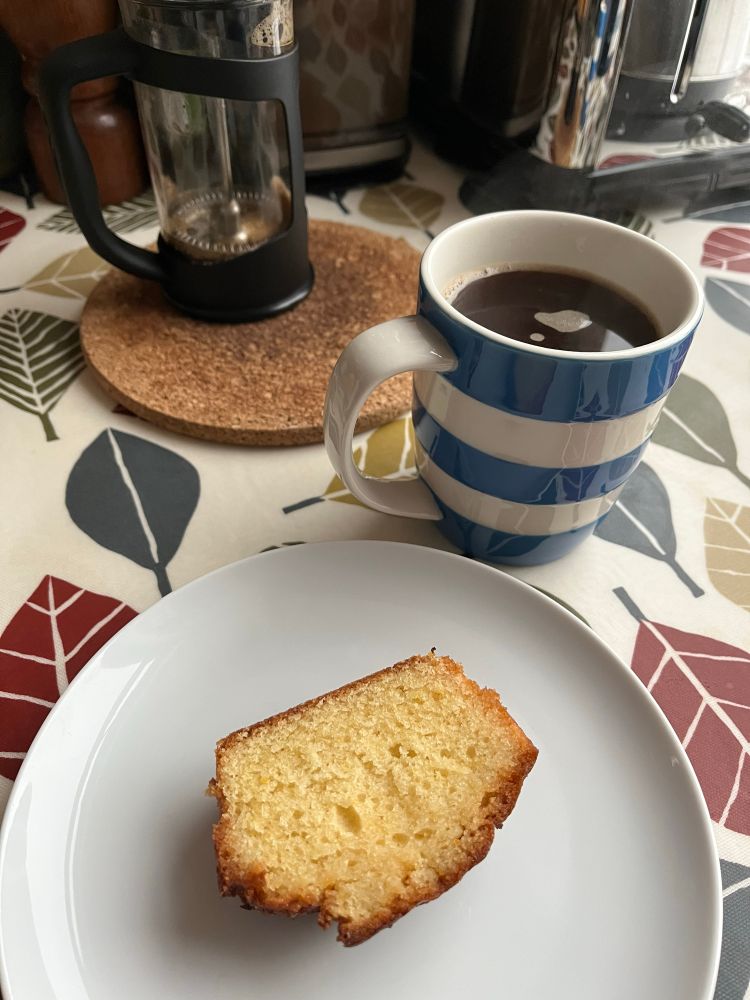 blue and white striped mug of string hot black coffee, with the end slice of my lemon drizzle cake on a plate. In your face, Monday