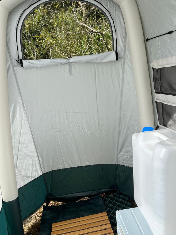 inside wash tent, looking at the showering end (other end is the composting toilet, which I haven't yet had to use but I'm sure the time will come when they're digging new drainage pipework). Wooden duckboard and semi-circular WINDOW! 20 litre water container for hand and teeth washing as required. *Yorkshire accent* luxury 