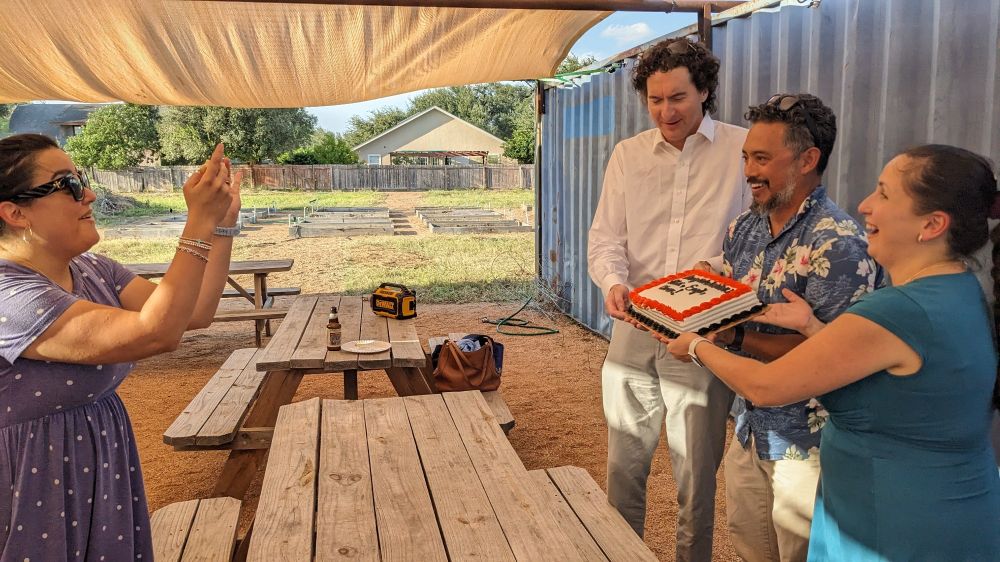 Owen Temby, Alex Racelis and Engil Pereira holding a tenure celebration cake