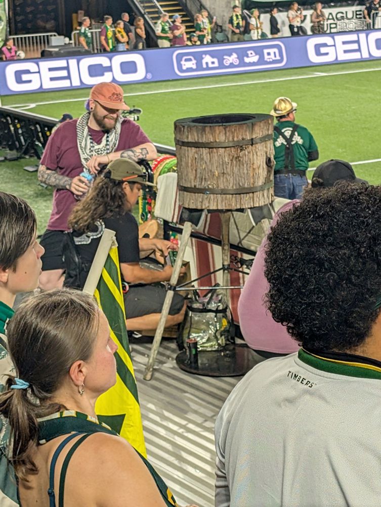 A member of the Timbers Army game day ops crew arrives at the main capo stand with a fresh box of green smoke bombs
