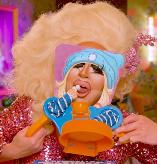 Trixie Mattel trying to eat tiny marshmallows without using her hands 