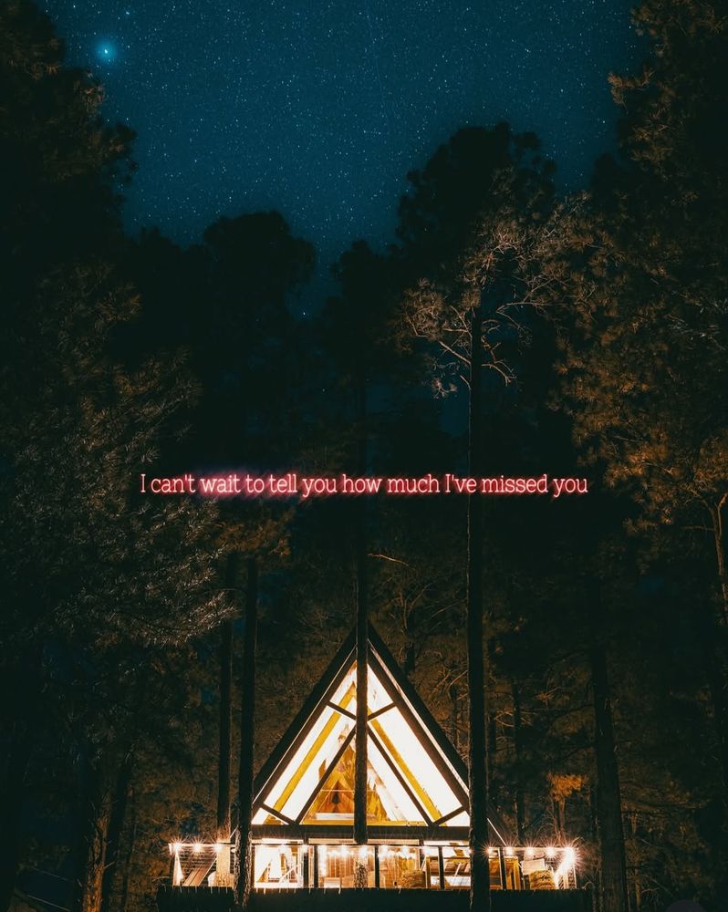 Pink neon words "I can't wait to tell you how much I've missed you" above an A-frame cabin in the woods 

Via IG @jeffreyczum 