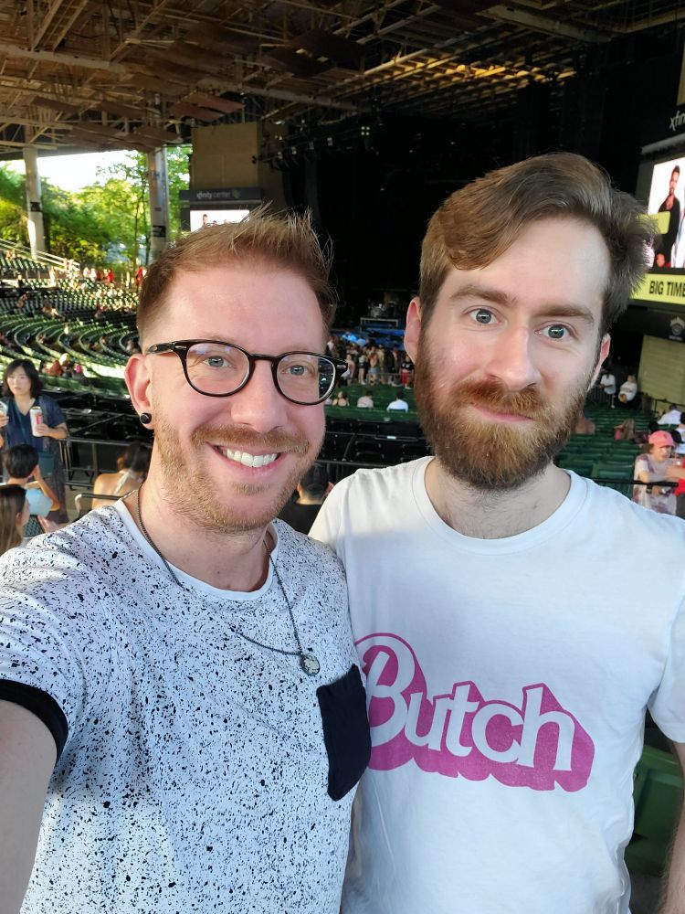 A picture of two homosexuals, one in a polka dot t-shirt and one in a white t-shirt that says "Butch" in the Barbie font.