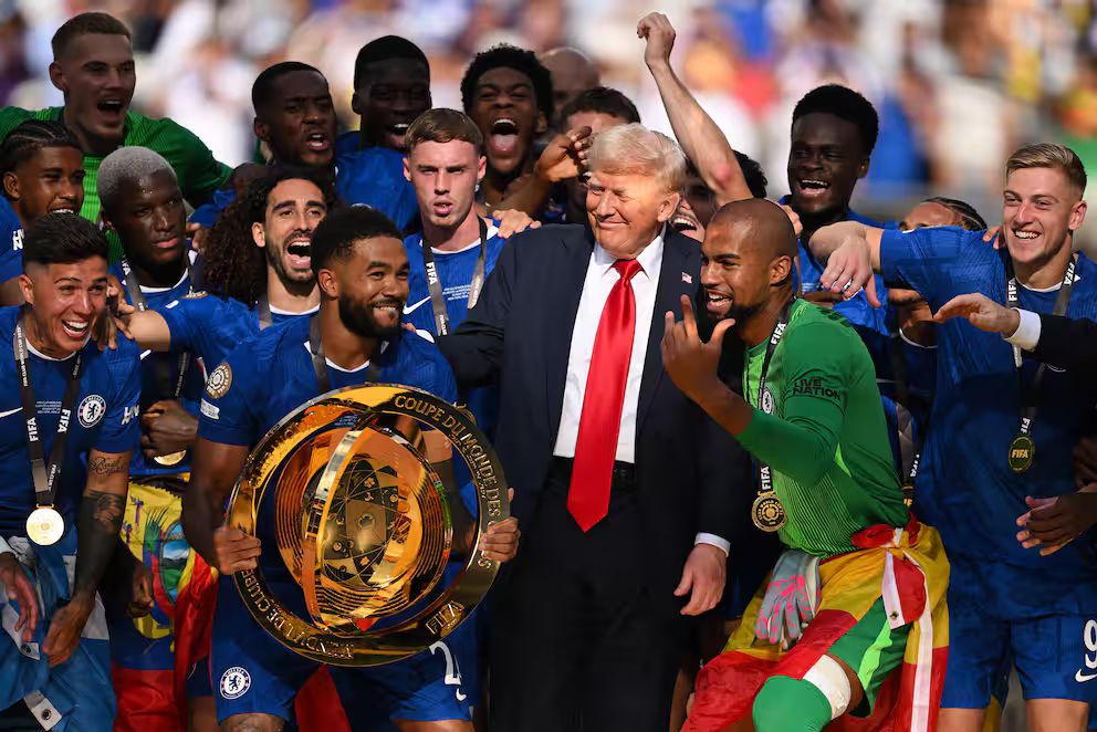 Trump looking like an idiot by hanging out onstage with celebrating soccer players who have no use for him.