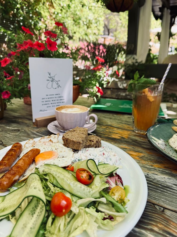Frühstück mit Salat Spiegelei so Jogurtsalat mit Radieschen saure Gurken kielbasa Brot und ein Cappuccino 