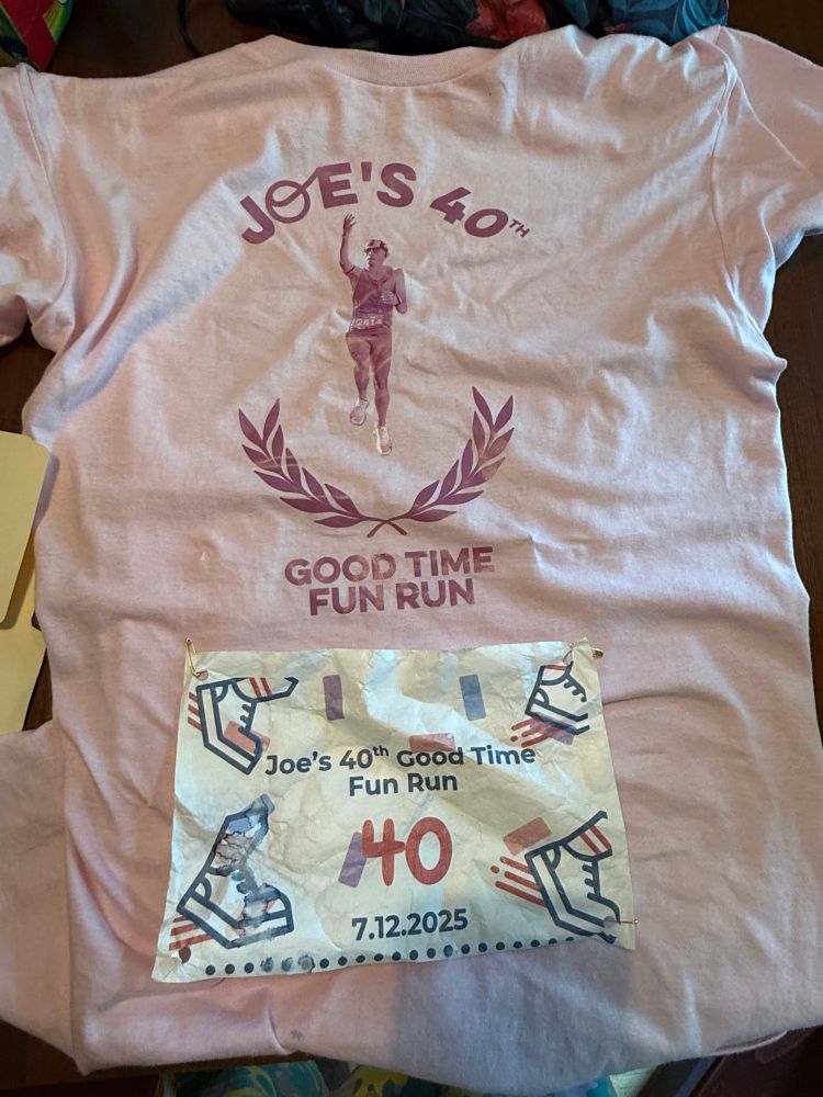 It’s a t-shirt and running bib for a 40th Birthday Fun Run. I’m doing a finger roll in the picture because I believe in finishing at the rim/finish line always. 