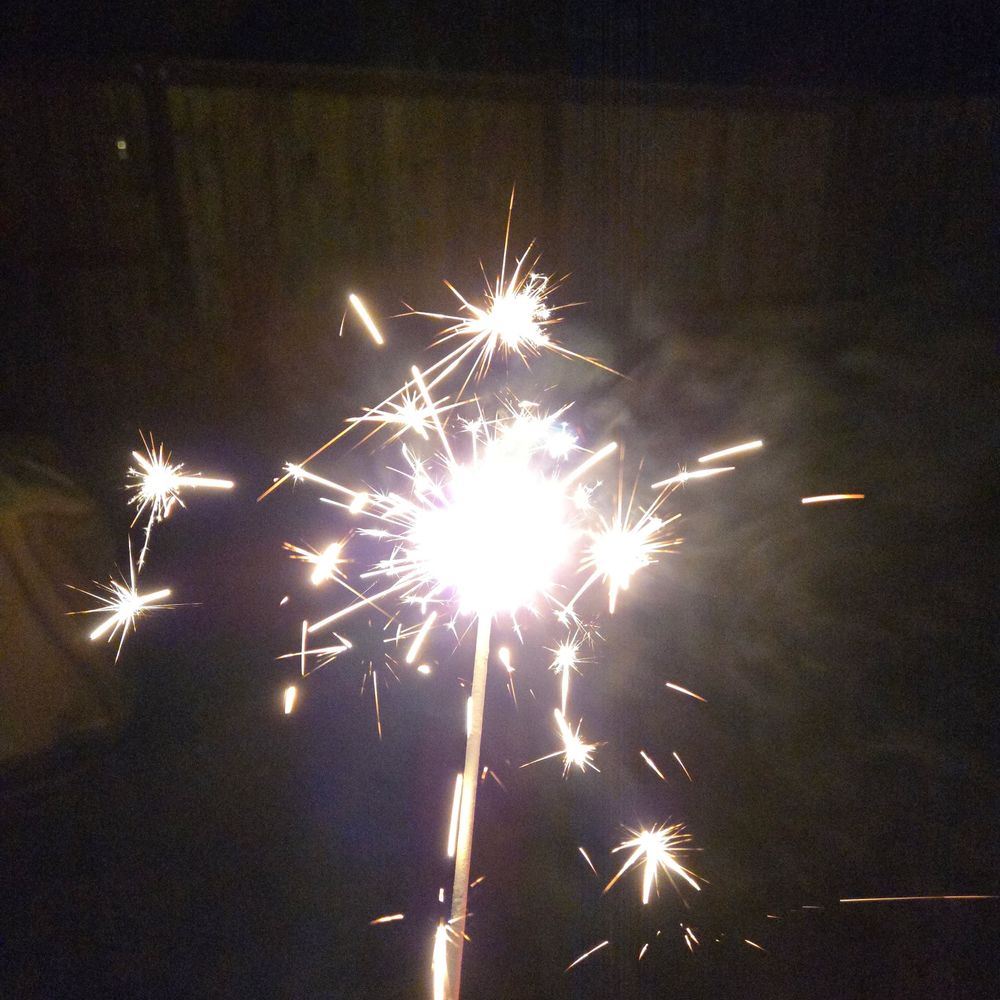 A lit sparkler in the night