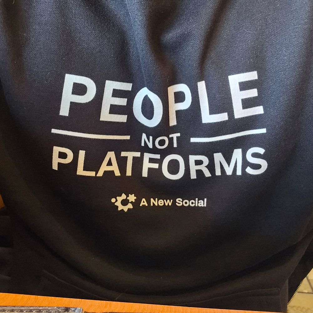 Close up of a hoodie with the text "People not platforms" along with "a new social" under it
