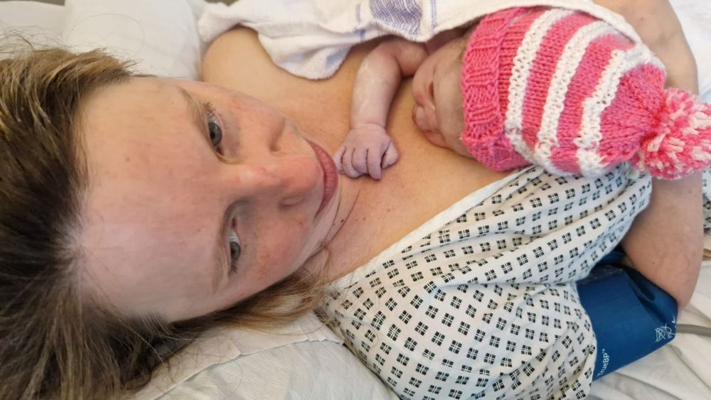 Newborn baby asleep on his mother's chest.