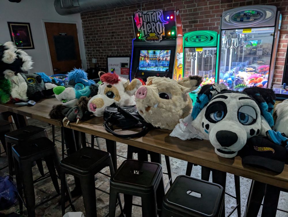 A variety of fursuit heads on the table including Chip.