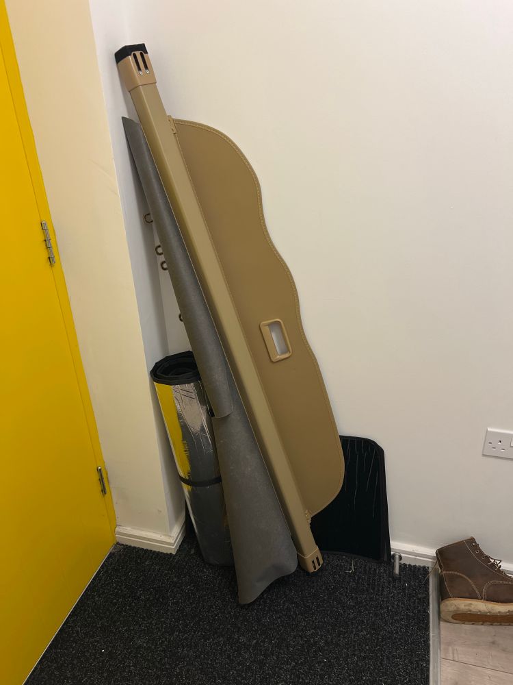 A roll-up load bay cover propped behind a door.