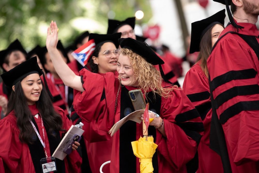 graduates smiling and waving
