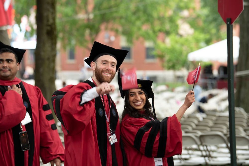 graduates waving flag and smiling