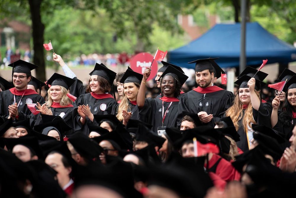 graduates waving flags smiling