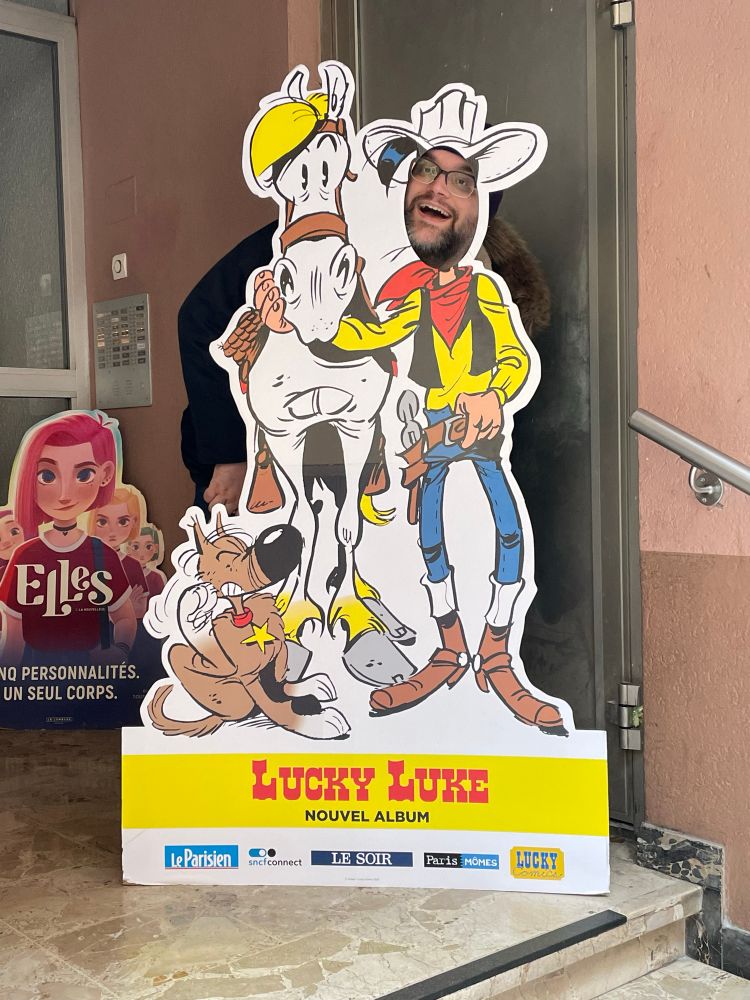 Me poking my dumb face through a cutout standee advertising the new Lucky Luke album in front of a French comic shop