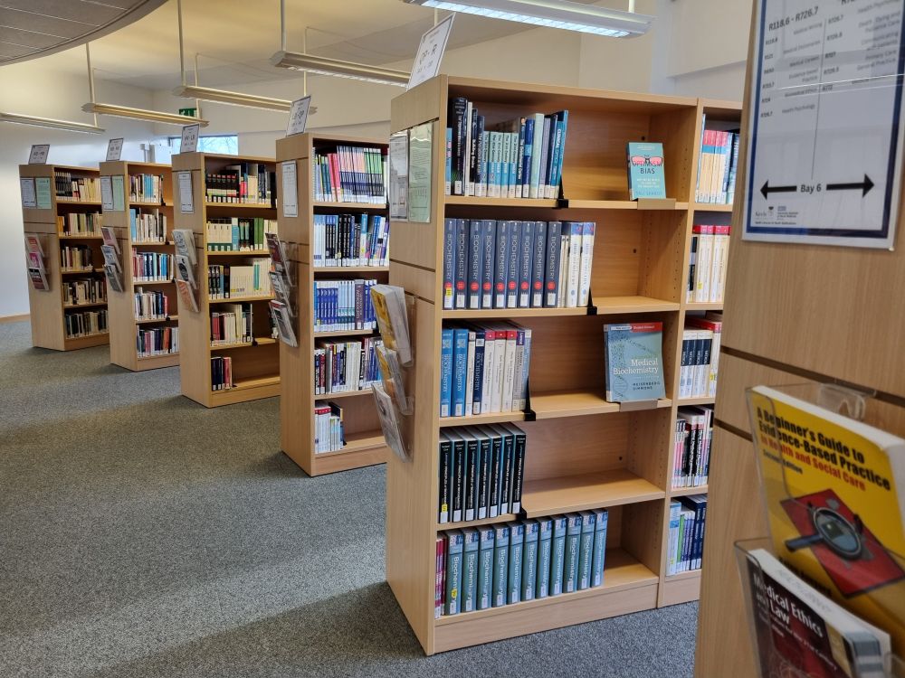 Books lined up on library shelves in the Health Library