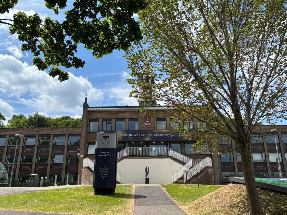 Keele University Library on a sunny day, with a leafy tree in the foreground