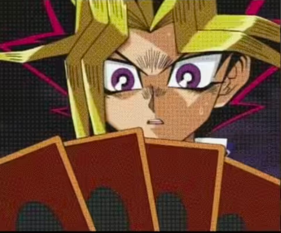 Yugi from the show yugioh staring despondently at a hand of cards