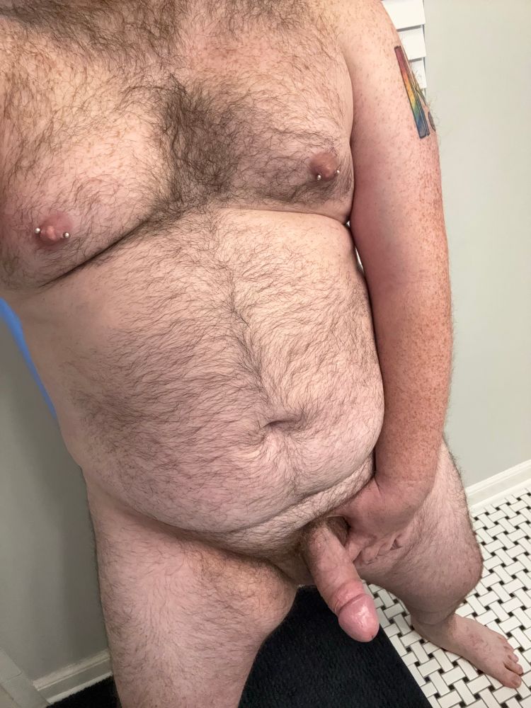 Selfie angle of my body. You can see my pierced nips, thick cock, and hairy chest/belly
