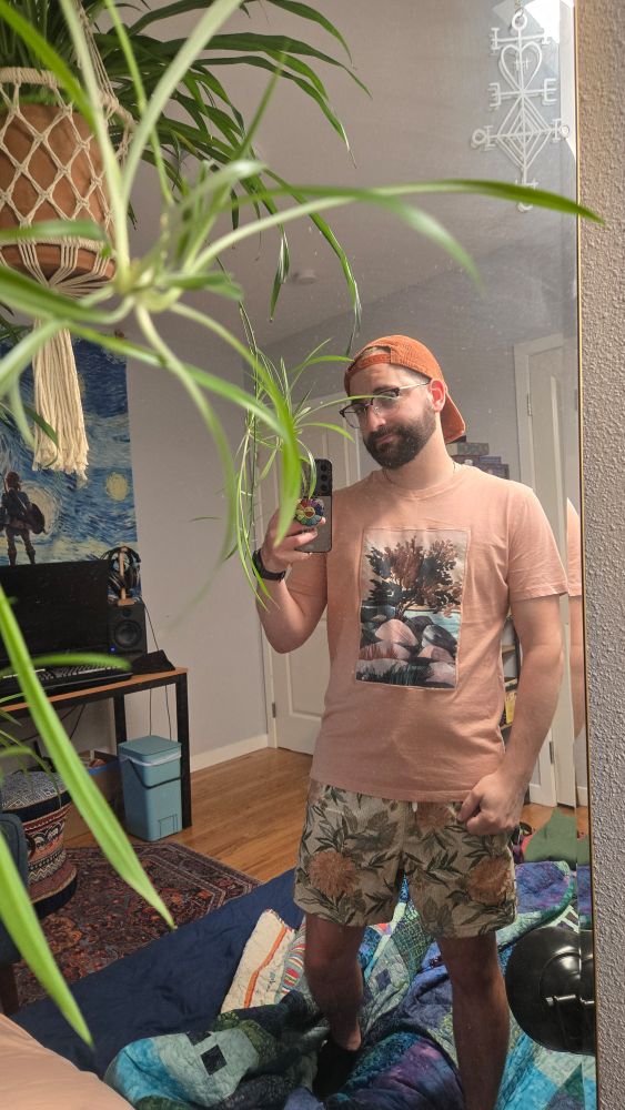 Gay man standing in front of a mirror with plants