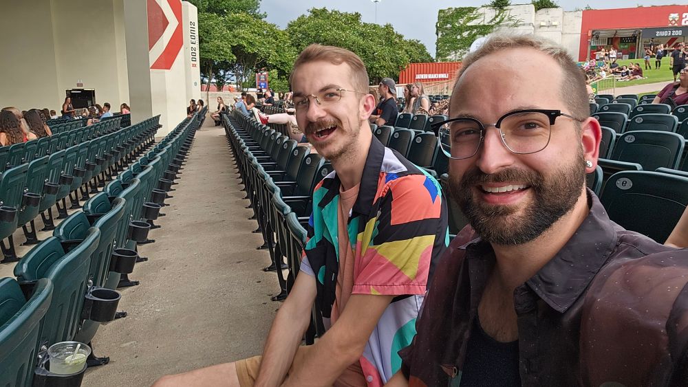 Two gays sitting at a pavilion waiting for Kesha
