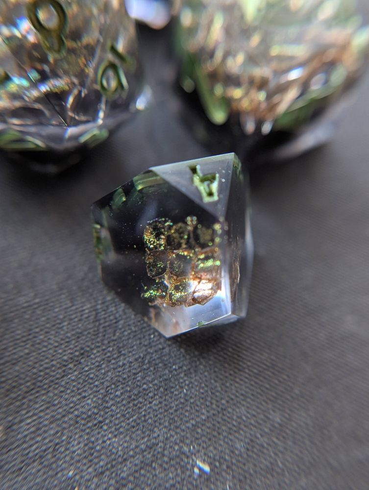 Handmade dice with snake shed painted gold, and metallic green numbers