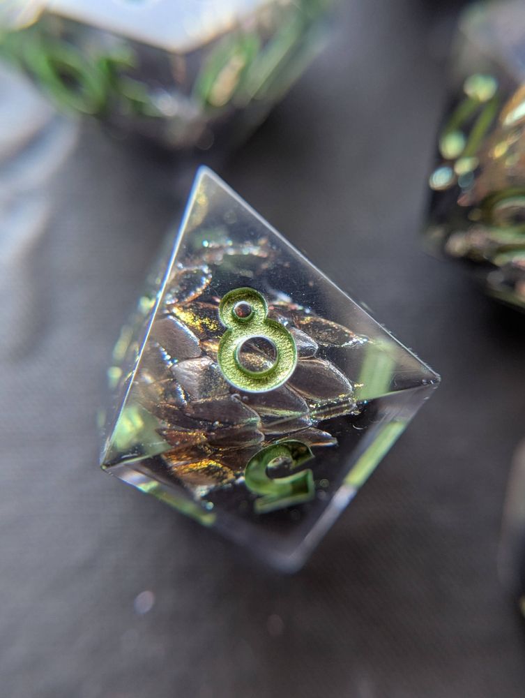 Handmade dice with snake shed painted gold, and metallic green numbers