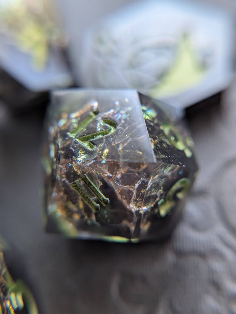 Handmade dice with snake shed painted gold, and metallic green numbers