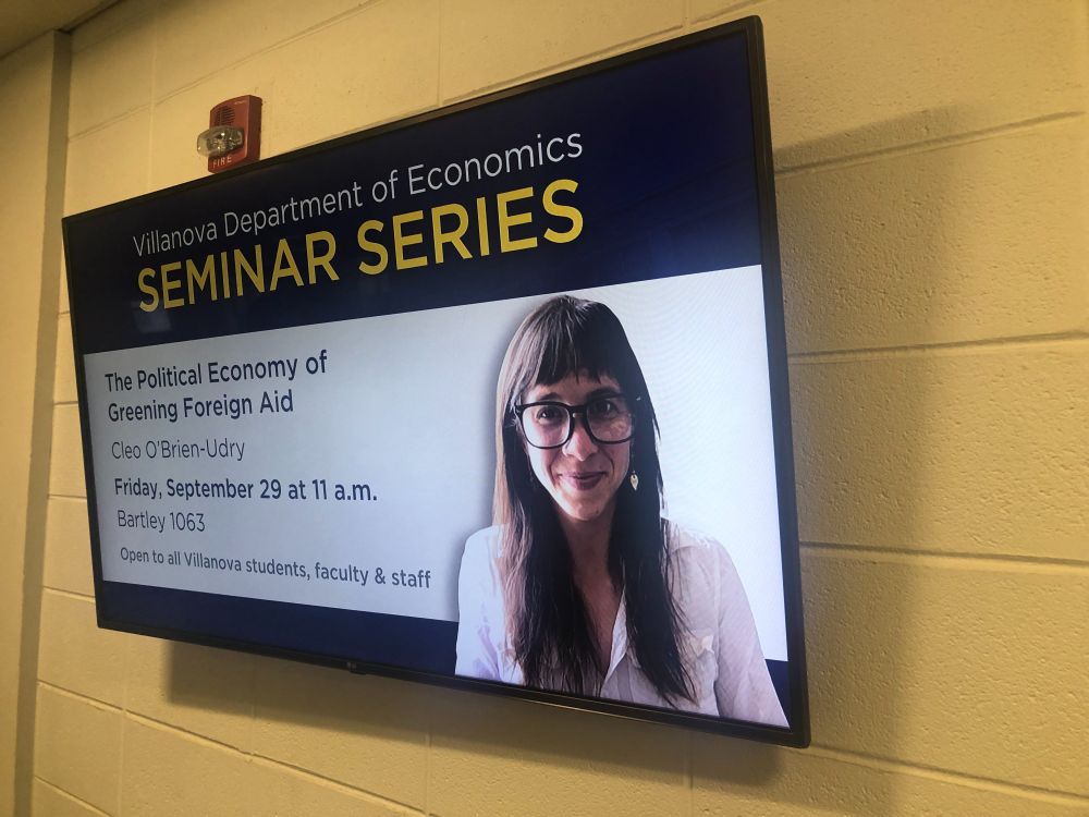 TV monitor with photo of Cleo and text "Villanova Department of Economics Seminar Series"