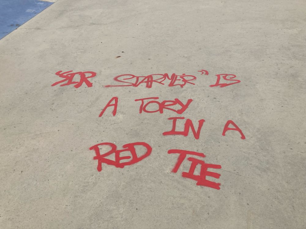 Red graffiti that says: “SIR STARMER” IS A TORY IN A RED TIE
