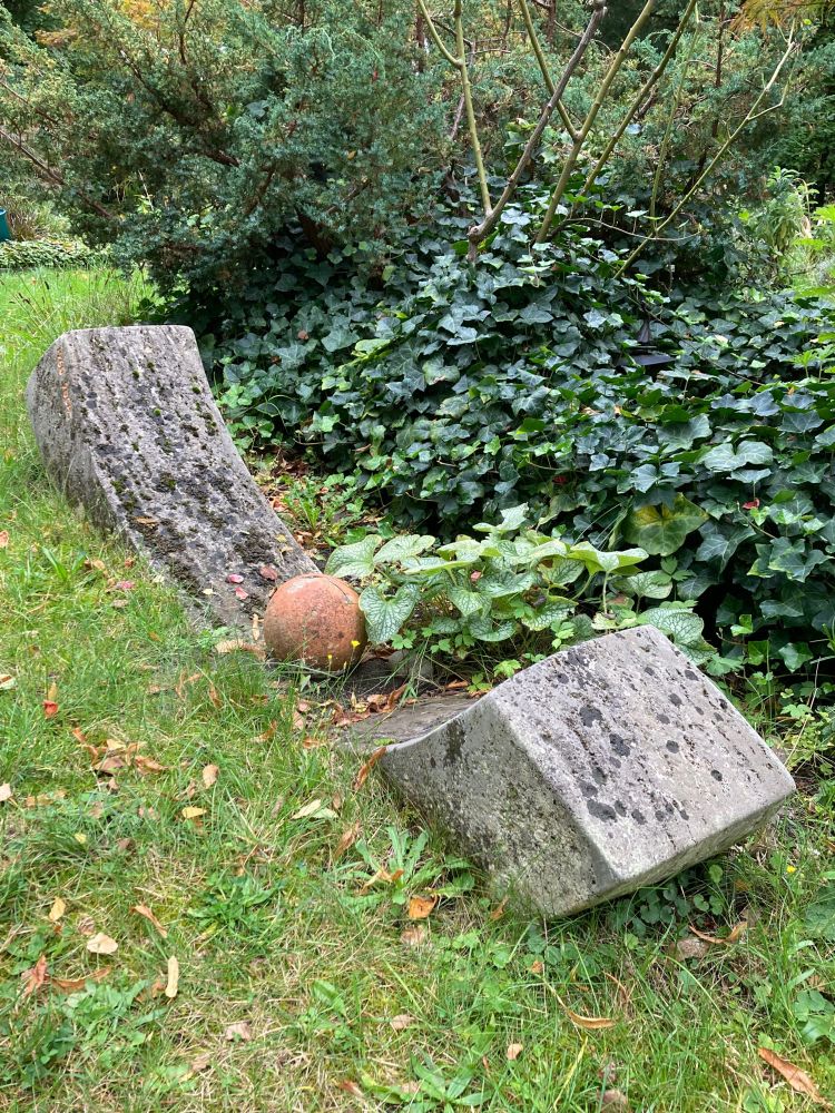 Der Grabstein besteht aus Granit und ist in Form einer steinernen Parabel gehauen.

Der Querschnitt ist quadratisch. Die Parabelform etwa 2 m lang und etwa 40 cm hoch.

Die Parabel ist ein kleines bisschen in die Rasenfläche rings umher eingelassen. Sie ragt an beiden Enden heraus. 

Die Parabel ist nicht beschädigt, allerdings fehlt ein Teil des Grabmonuments. Auf der Parabel lag früher eine Granitkugel.
Sie lag lose und war nicht befestigt.
Irgendwann war die Kugel weg.
Später hat jemand sie durch eine etwas kleinere Tonkugel ersetzt.

Neben dem Grab wächst ein kleiner Baum um seinen Fuß rankt sich Efeu. Ein Kaukasusvergissmeinnicht wächst neben der Parabel hoch.
