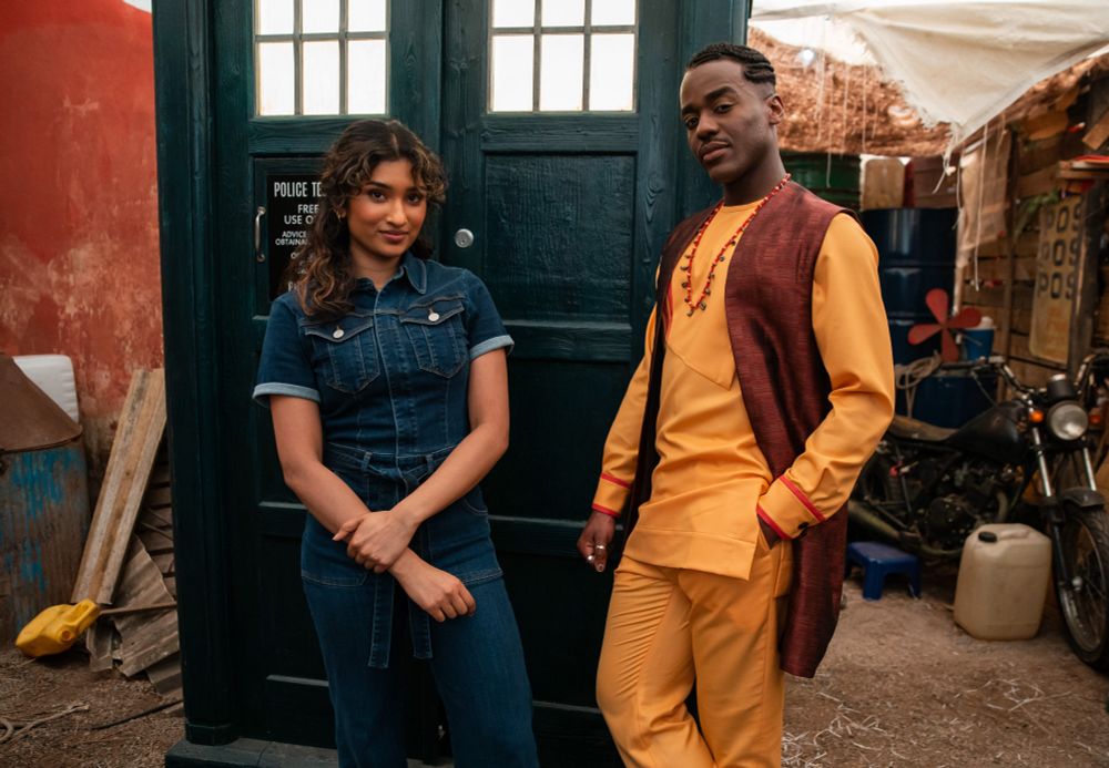 Belinda and the Doctor are standing at the doors of the TARDIS, ready to roam the streets of Lagos. 