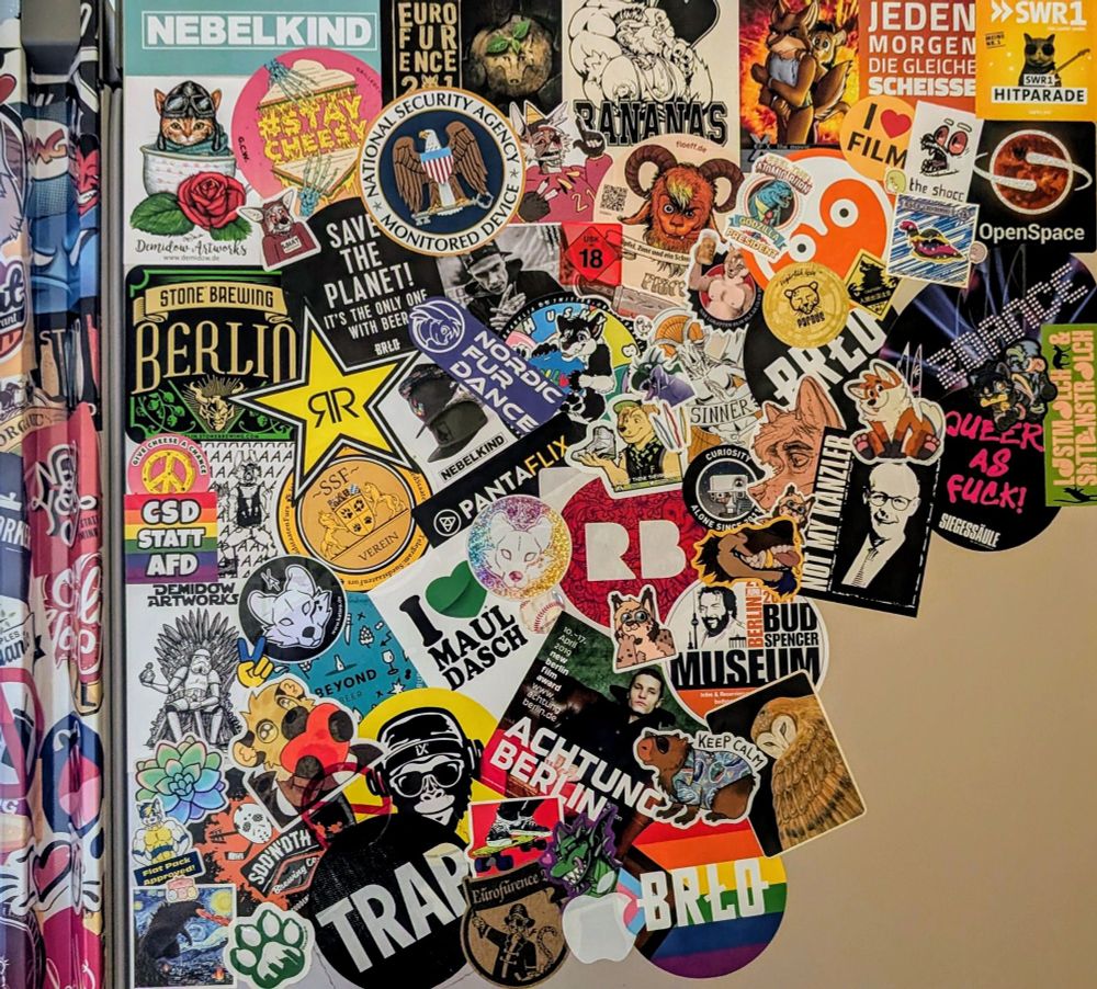 One side of my fridge partly covered in stickers. Some of them showing colorful furry characters (you guys!) and some showing logos, brands and some nice messages.