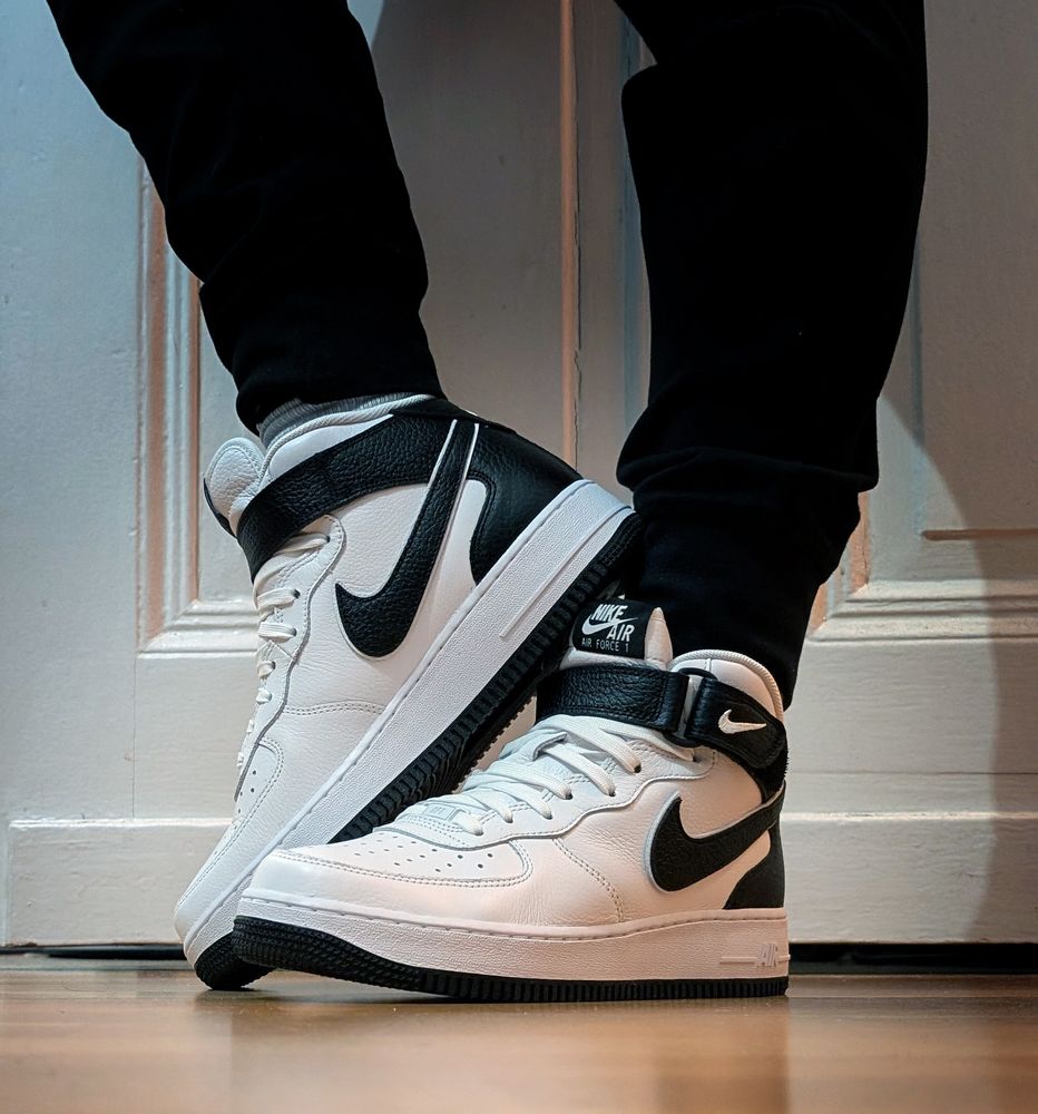Dragon paws from the side with some mid black and white AirForce1's on. 