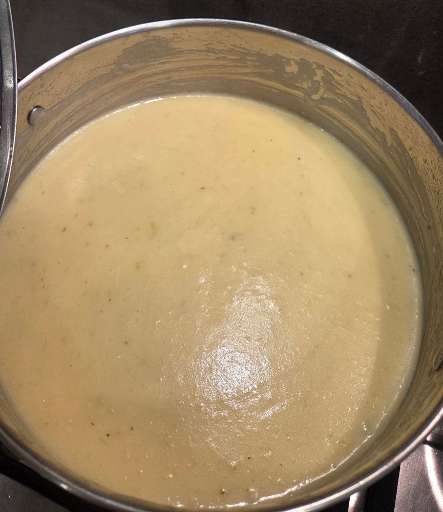 A saucepan full of a creamy looking soup.