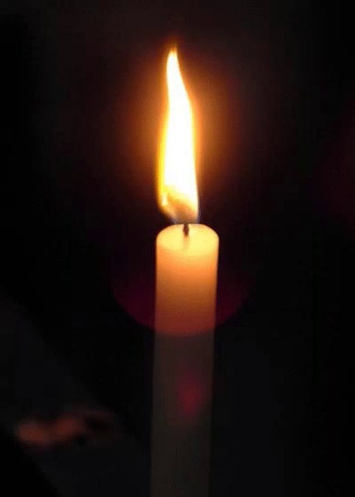 a candle is lit up in the dark with a flame coming out of it